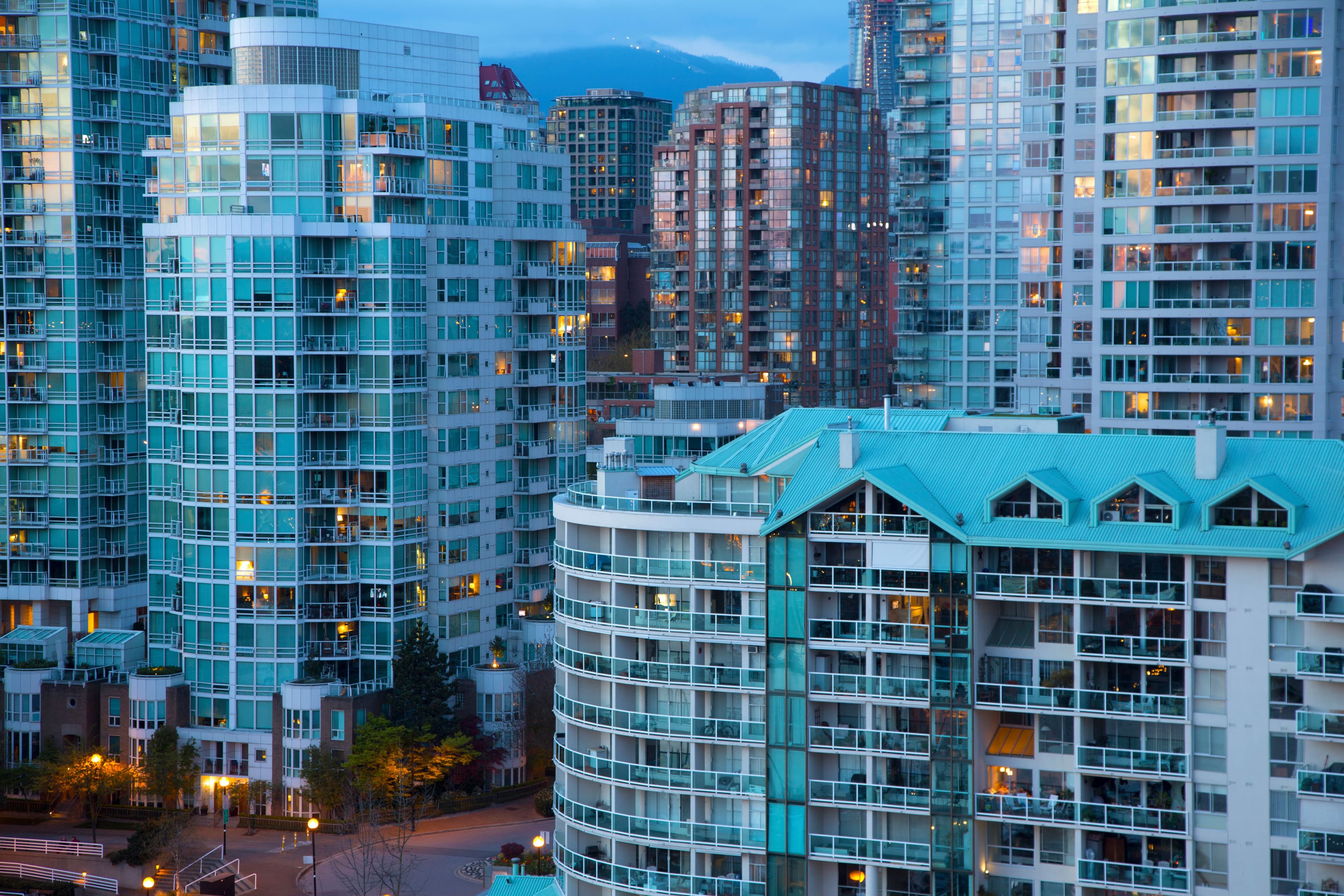 Cityscape with illuminated skyscrapers and apartment buildings.